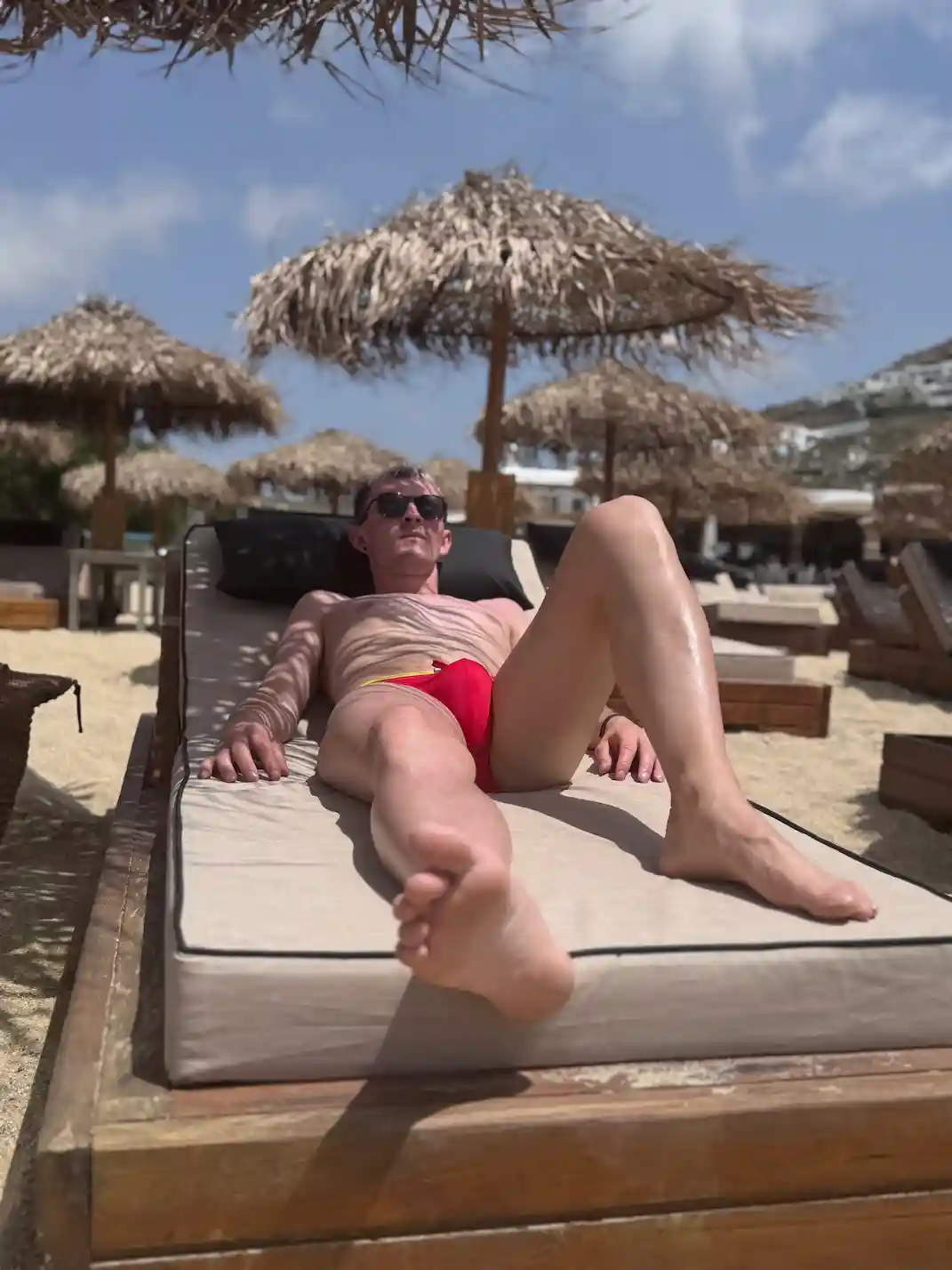 Alex wearing red swimming trunks enjoying the sun in Europe's beaches