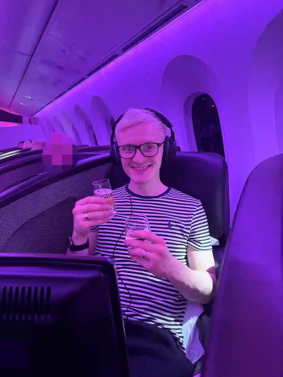 Alex with a glass of champgane on the Virgin 787 to Cape Town
